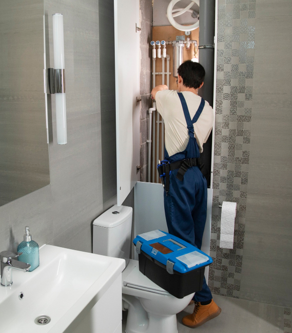 Professional bathroom renovation technician working on plumbing system – Pro Dallas Bathroom