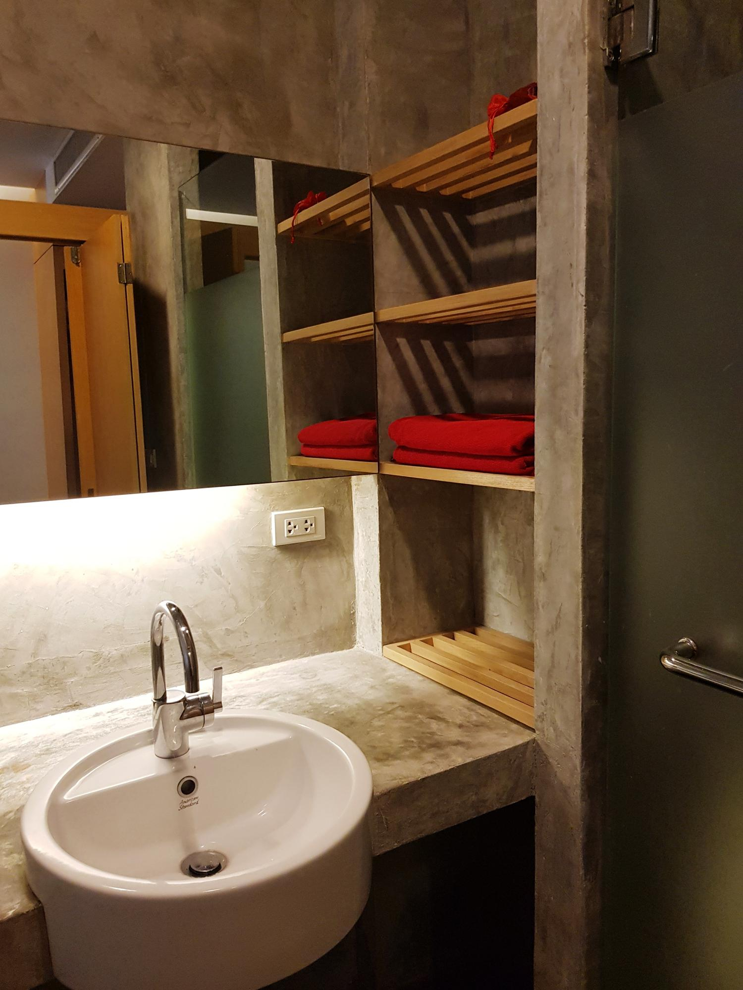 Modern bathroom vanity with concrete shelves and wall mirror